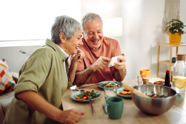istock Senior couple using phone while having breakfast at their apartment 1484555125