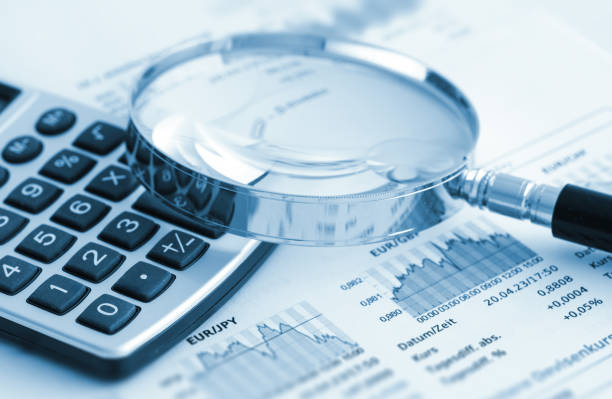 istock Magnifying glass, calculator and charts on paper 1484556993