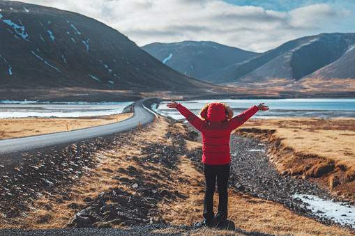 Happy tourist traveler woman enjoying with open arms on ring road in Iceland, Europe travel vacation