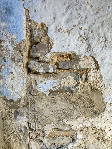 texture of a deteriorated old wall, with a partially repaired spalling, vertical