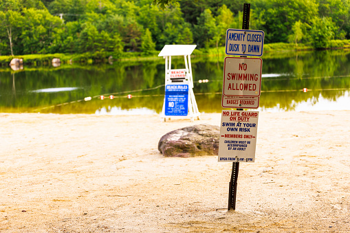 Empty beach on the lake with warning signs.