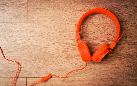 Modern orange headset headphones on the table