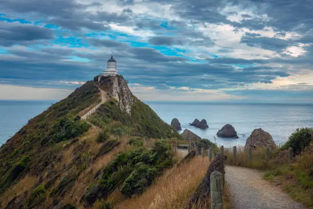Photo of Nugget Point (Tokata). Iconic promontory on the Otago coast, the Catlins, South Island, New Zealand. Crowned by a lighthouse surrounded by rocky islets (The Nuggets). Home to penguins, gannets, royal spoonbills, fur seals