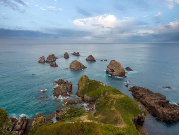 Photo of Nugget Point (Tokata). Iconic promontory on the Otago coast, the Catlins, South Island, New Zealand. Crowned by a lighthouse surrounded by rocky islets (The Nuggets). Home to penguins, gannets, royal spoonbills, fur seals