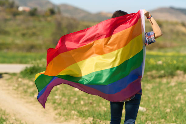 istock unrecognizable Queer person waving rainbow flag 1484577236