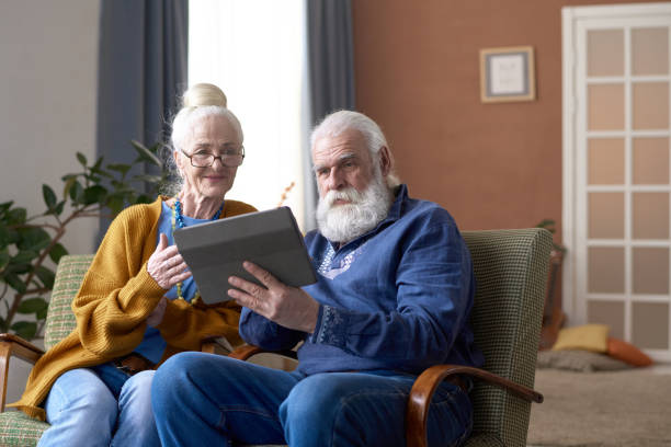 自宅でタブレットpcを使用する老夫婦 - senior adult couple computer retirement ストックフォトと画像