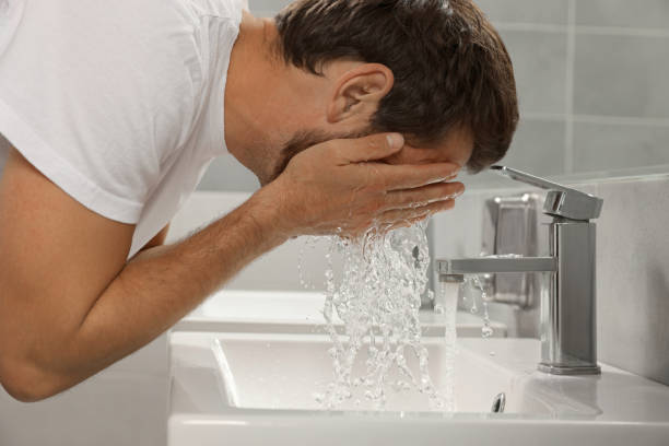 istock Handsome man washing face in bathroom, closeup 1484582916