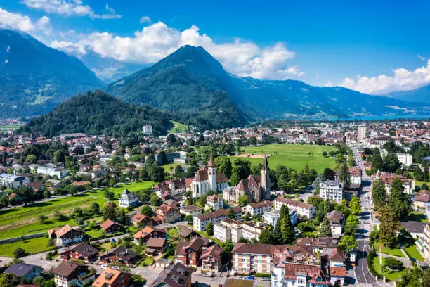 Photo of Aerial view over the city of Interlaken in Switzerland. Beautiful view of Interlaken town, Eiger, Monch and Jungfrau mountains and of Lake Thun and Brienz. Interlaken, Bernese Oberland, Switzerland.
