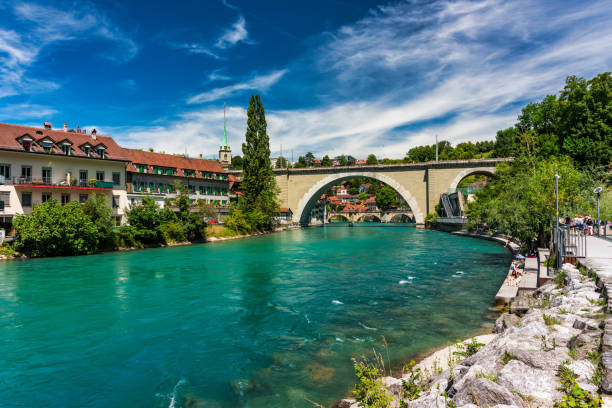 blick auf die berner altstadt und die nydeggbrücke über die aare, bern, schweiz. berner altstadt mit der aare, die an einem sonnigen tag um die stadt fließt, bern, schweiz. - nydeggbrucke stock-fotos und bilder