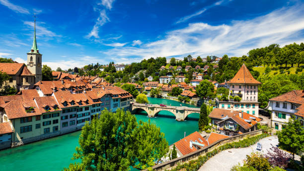 blick auf die berner altstadt und die nydeggbrücke über die aare, bern, schweiz. berner altstadt mit der aare, die an einem sonnigen tag um die stadt fließt, bern, schweiz. - nydeggbrucke stock-fotos und bilder