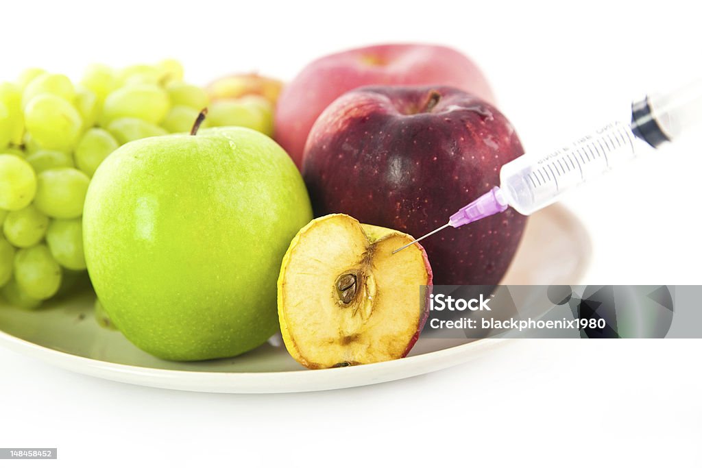 Fruits Syring injected into an apple fruit, can be used for healthy concept Apple - Fruit Stock Photo