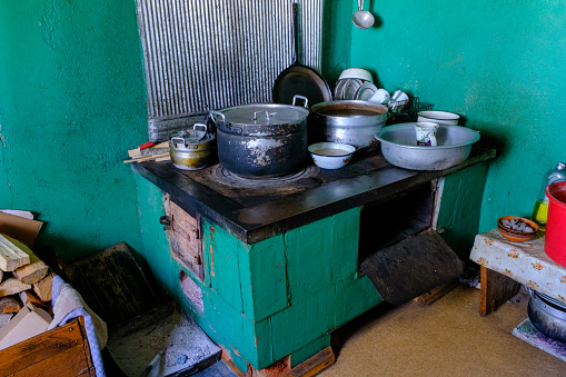 Interior of the kitchen of an old country house. Old cooking stove with dishes. The kitchen is in use.