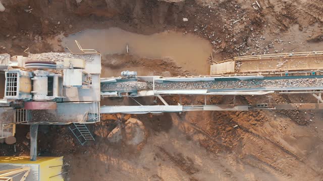 Jaw crusher plant with belt conveyor puts crushing stone and screening sand, aerial top view