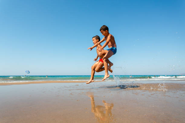 istock Children running and jumping on the beach 1484596863