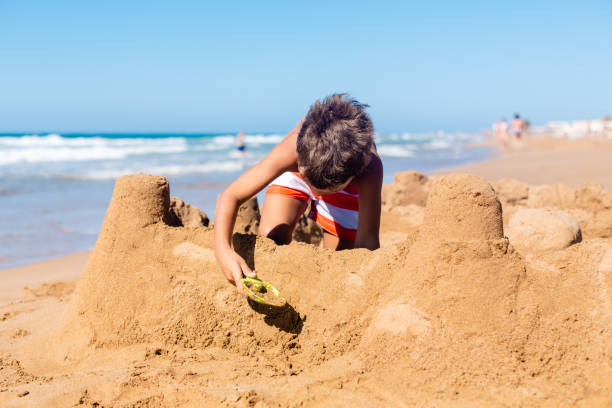 istock Boy building sand castle on the beach 1484597084
