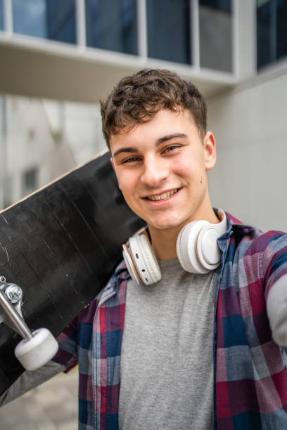 屋外の18歳または19歳の若い白人男性の肖像画 - free standing audio ストックフォトと画像