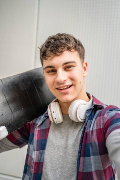 屋外の18歳または19歳の若い白人男性の肖像画 - free standing audio ストックフォトと画像