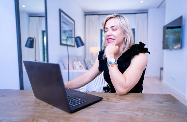 istock blonde girl smiling and talking video call on laptop working remotely 1484606473