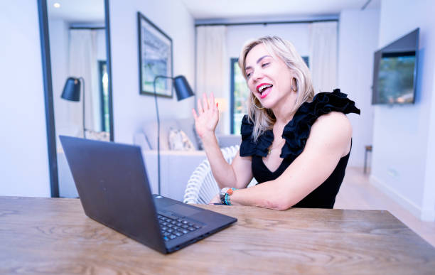 istock Smiling woman waving hand during video chat on laptop 1484606476