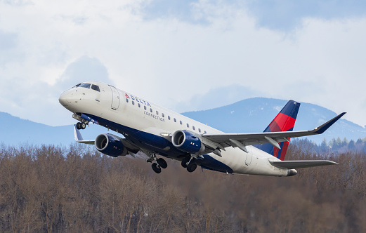 Portland, Oregon, USA -April 1st, 2023: A Delta Connection Embraer 175 takes off from runway 28R at Portland International Airport.