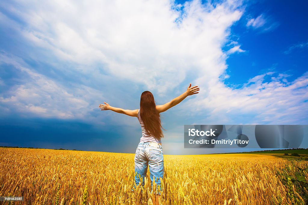 Girl with outstretched arms is enjoys summer day Girl with outstretched arms is enjoys summer day in the field Adult Stock Photo