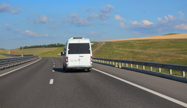 istock Minibus moves along a suburban highway 1484638825