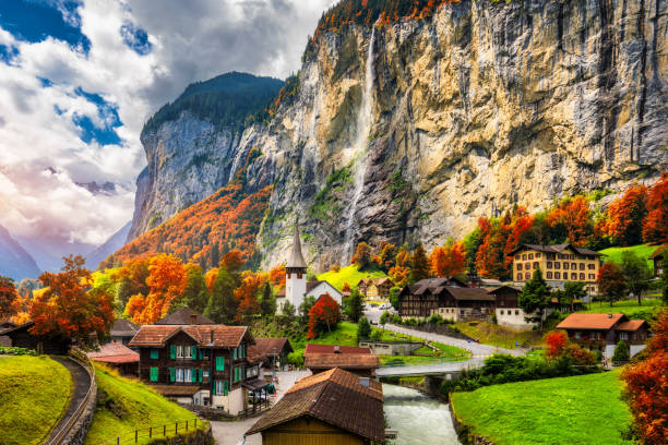 라우터브루넨 계곡의 매혹적인 가을 풍경과 멋진 슈타우바흐 폭포와 일몰 시간에 스위스 알프스가 펼쳐집니다. 가을 붉은 단풍이 있는 라우터브루넨 마을, 베르너 오버란트, 스위스, 유럽. - meadow autumn hiking mountain 뉴스 사진 이미지