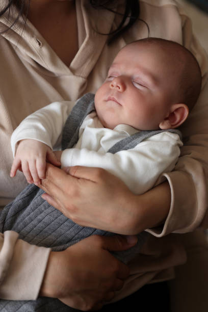 istock Newborn boy sleeping on his mother's lap 1484653793