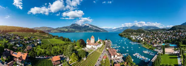 Aerial panoramic view of Spiez Church and Castle on the shore of Lake Thun in the Swiss canton of Bern at sunset, Spiez, Switzerland. Spiez Castle on lake Thun in the canton of Bern, Switzerland.