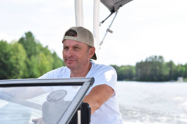 istock Middle aged man driving boat on a lake 1484657230
