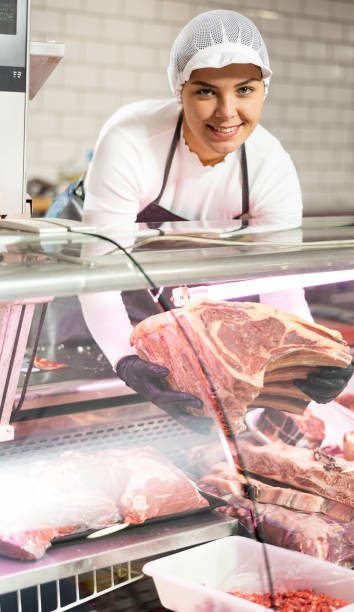 istock Young woman puts beef ribs in showcase 1484658547