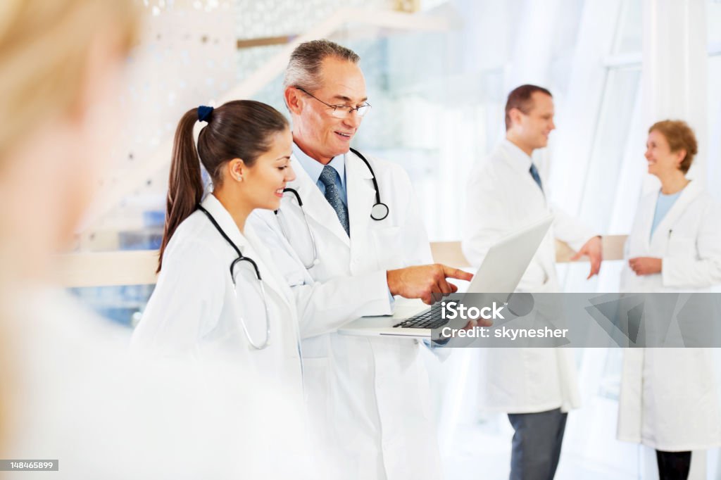 Dois médicos, olhando para o laptop. - Foto de stock de Apontar - Sinal Manual royalty-free