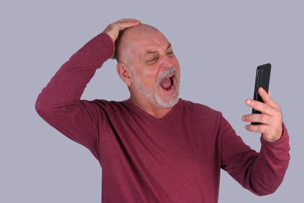 istock bald adult man showing cell phone handset technology edition 1484666371