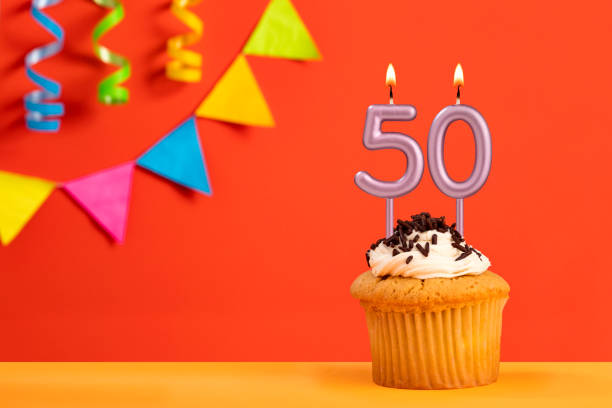 istock Number 50 Candle - Birthday cake on orange background with bunting 1484668033