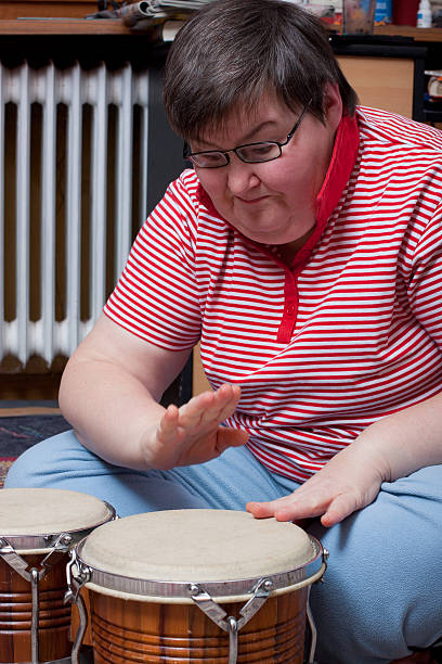 istock Disabled woman in striped shirt plays bongo drums 148467028