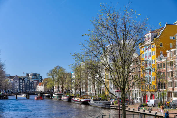 case iconiche lungo le strade e i canali di amsterdam - flowing river water dam foto e immagini stock