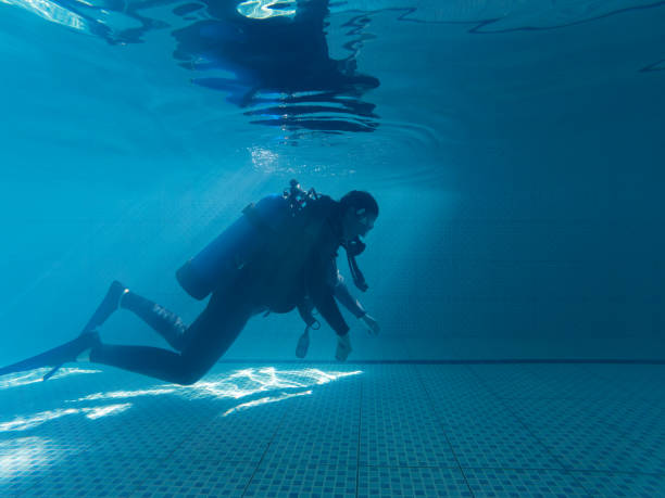 istock Young woman in wetsuit practicing in swimming pool 1484672374