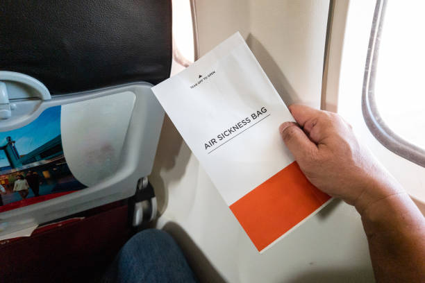 istock Passanger holding air sickness bag during air flight incase need to vomit 1484678750