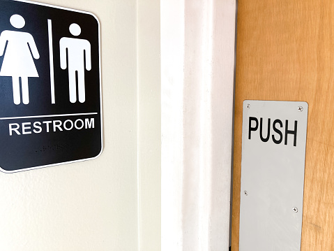 Gender Neutral Sign and Restroom Door (Close-Up)