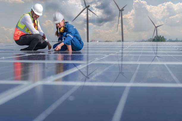 An engineer with a manager checks the efficiency of the solar cells to ensure that they are operating at their optimum capacity. Look for any areas where there is room for improvement or optimization. stock photo
