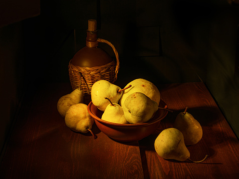 Ripe yellow pears on a wooden table and black background. Still life.