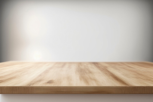 Empty wooden table top against white blurred background