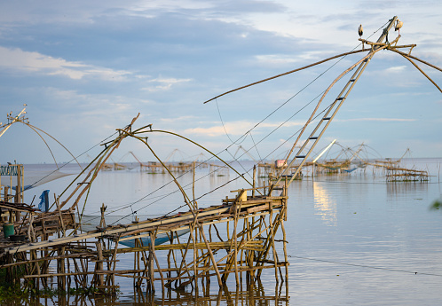 Cochin, India - September 04, 2012. Men working in the Chinese fishing net. Using ropes, they hold the counterweights that allows them to get on and off the fishing net then check on the net