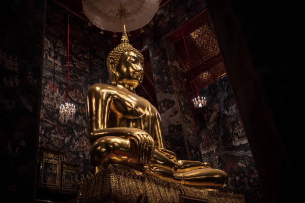 Medium shot of Golden Buddha statue in temple.