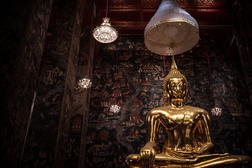 Medium shot of Golden Buddha statue in temple.