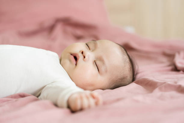 istock image of a newborn baby lying on a pink bed 1484709737