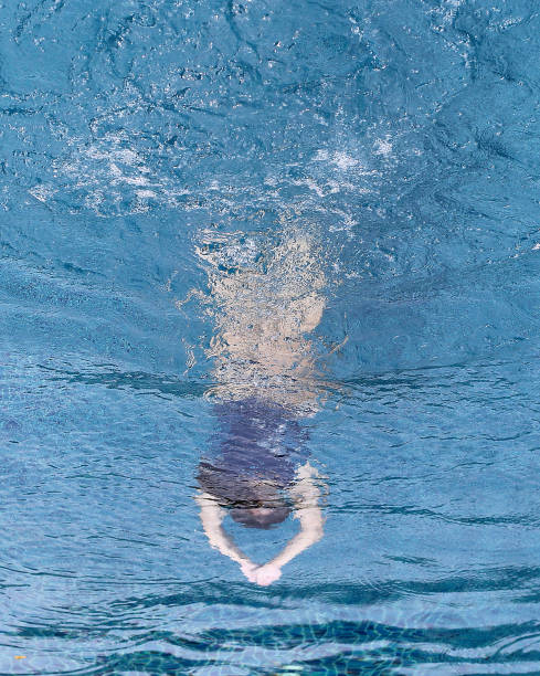 An Asian young woman is swimming confidently