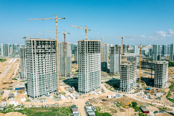 istock high-rise apartment buildings under construction with cranes on clear blue sky background. aerial view. 1484713671