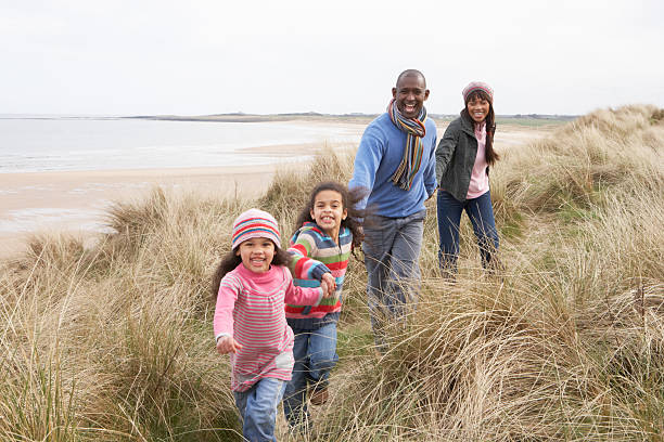 istock Family Walking Along Dunes On Winter Beach 148471421