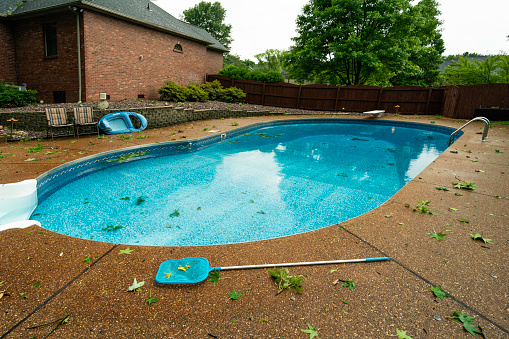 Messy pool and patio after a windy rain storm at a residential home, Midwest, Indiana, USA